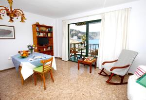 a living room with a table and chairs and a balcony at ca na JB in Port de Soller