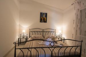 a bedroom with a metal bed with a pair of glasses on it at Apartments Iva in Trogir