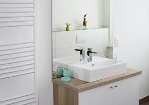 a bathroom with a white sink and a mirror at Ferienhaus Brockenbahnblick in Wernigerode