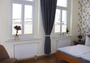 a bedroom with two windows and a bed in it at Ferienhaus Brockenbahnblick in Wernigerode