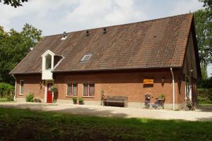 une grande maison en briques avec deux vélos garés à l'extérieur dans l'établissement Bed & Breakfast aan de Beek, à Arcen