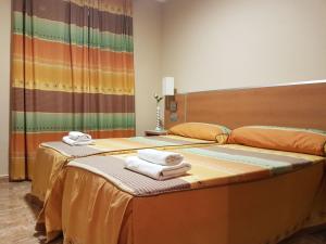 two beds in a hotel room with towels on them at Camping-Hotel Los Molinos in Ruidera