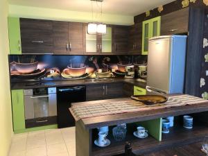a kitchen with wooden cabinets and stainless steel appliances at GALA APARTMENT in Veliko Tŭrnovo