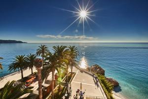 a view of a beach with palm trees and the ocean at Hotel Balcón de Europa in Nerja