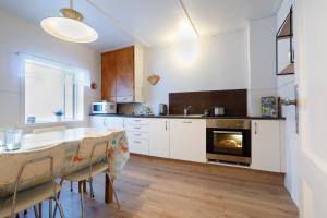 a kitchen with white cabinets and a table and a fireplace at Original North in Þingeyjarsveit