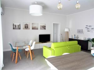 リミニにあるNew & modern apartment on the seaのリビングルーム(緑のソファ、テーブル付)