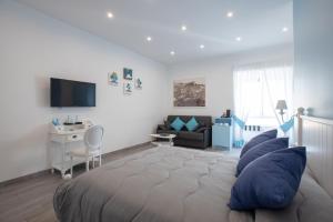 sypialnia z łóżkiem z niebieskimi poduszkami i biurkiem w obiekcie Suite Napoletana w mieście Napoli