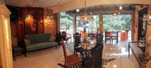 a living room with a couch and a table and chairs at Nanda's House Pousada in São Francisco de Paula