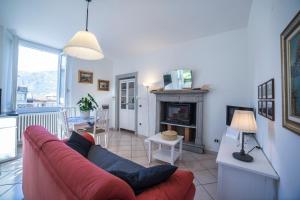 a living room with a red couch and a fireplace at Casa Bertul in Lezzeno