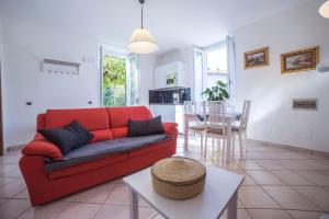 sala de estar con sofá rojo y mesa en Casa Bertul, en Lezzeno