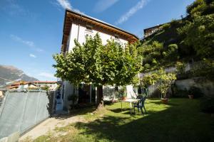 a small yard with a table and a tree at Casa Bertul in Lezzeno