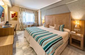 a hotel room with a large bed and a television at Hotel Balcón de Europa in Nerja