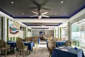a dining room with blue tables and chairs and a ceiling at Hotel Balcón de Europa in Nerja