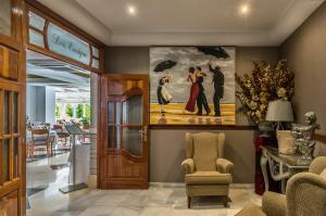 a lobby with a painting of a couple with umbrellas at Hotel Balcón de Europa in Nerja