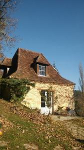 an old stone house with a roof on a hill at Petite Maison en Périgord Noir in Plazac