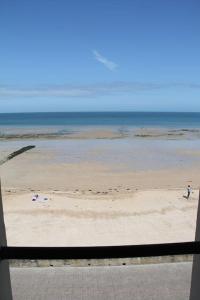 vistas a una playa con gente en la arena en On The Beach, en Saint-Aubin-sur-Mer