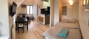 a small bedroom with a bed and a dining room at Jouy La longère, proche Hec, Versailles, parking privé gratuit in Jouy-en-Josas