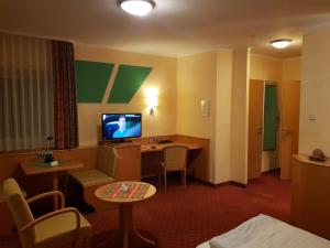 a hotel room with a desk and a tv at Hotel-Restaurant Fröhlich in Kaiserslautern