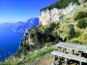 a wooden bench sitting on the side of a mountain at Domus Gaia in Amalfi
