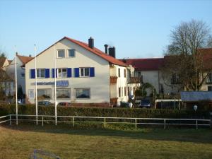 una casa blanca con una valla delante en Hotel-Restaurant Fröhlich, en Kaiserslautern