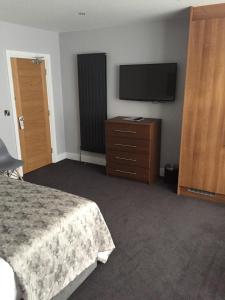 a hotel room with a bed and a flat screen tv at Carlton Hotel in Ilfracombe