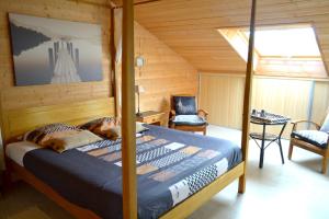 LanildutにあるChambres d'Hôtes Le Nid d'Iroiseの木製の部屋にベッド1台が備わるベッドルーム1室があります。