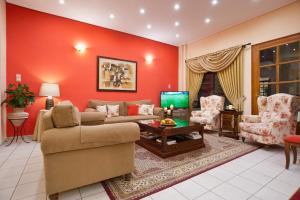 sala de estar con paredes rojas, sofá y sillas en Pan Hotel en Delfos