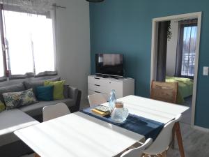 a living room with a white table and a couch at Fox apartman A11 in Zamárdi