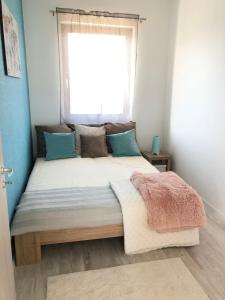 Un pat sau paturi într-o cameră la Fox apartman A11