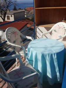 una mesa y dos sillas con un mantel azul. en House Kaić, en Selce