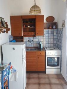 a kitchen with a white stove and a refrigerator at House Kaić in Selce