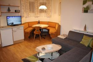 uma sala de estar com um sofá e uma mesa em Appartements Eggenhofer em Sankt Jakob in Defereggen