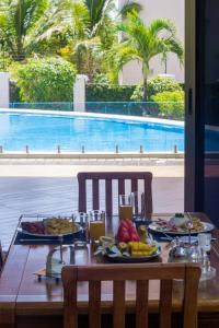 a table with food on it next to a swimming pool at Seaclusion Diani in Diani Beach