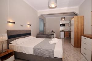 a bedroom with a large bed and a kitchen at Kalimera Apartments in Kassiopi