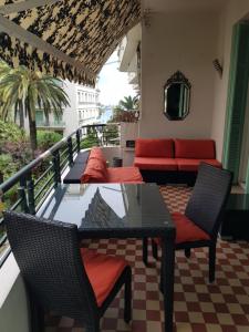 a balcony with a table and chairs and a couch at Capitole Bleu in Nice
