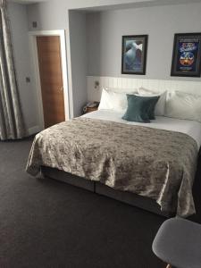 a bedroom with a large bed with a large bedspread at Carlton Hotel in Ilfracombe