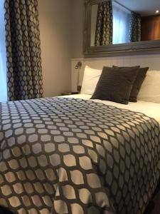 a large bed with a black and white comforter at Carlton Hotel in Ilfracombe