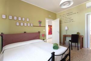 a bedroom with a white bed and a desk and a table at B&B I Poeti in Collecorvino