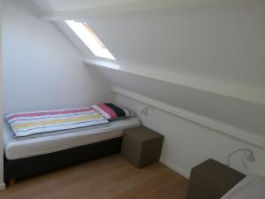 Habitación pequeña con cama y tragaluz en Terrasses de Malmedy 453, en Malmedy