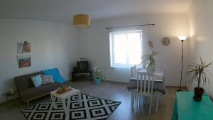 een woonkamer met een bank en een tafel bij Jardim à vista in Aveiro