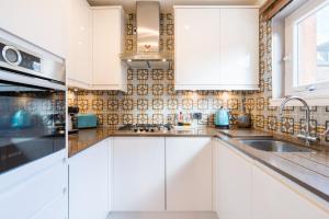 a kitchen with white cabinets and a sink at The Queens View in Edinburgh