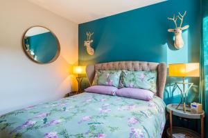 um quarto com uma cama e uma parede azul em The Queens View em Edimburgo