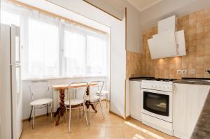 a kitchen with a table and chairs in a room at ARTAL Apartment Yordanska Street 22 in Kyiv