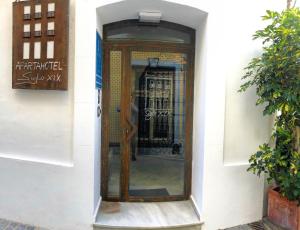 - une porte en bois dans un bâtiment blanc dans l'établissement Apartahotel Siglo XIX, à Tarifa