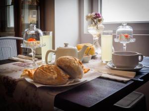 una mesa con pan, café y leche. en Memórias Charme Residences, en Covilhã