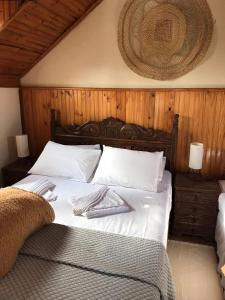 a bed with white sheets and two towels on it at Caminho das Lavras in Lavras Novas