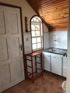 a kitchen with a white door and a sink at Caminho das Lavras in Lavras Novas
