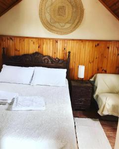 a bedroom with a bed with a wooden wall at Caminho das Lavras in Lavras Novas