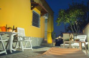 a yellow building with tables and chairs in front of it at Villalba in Balestrate