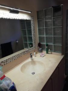 a bathroom with a sink and a large mirror at Villa Maria in Somone